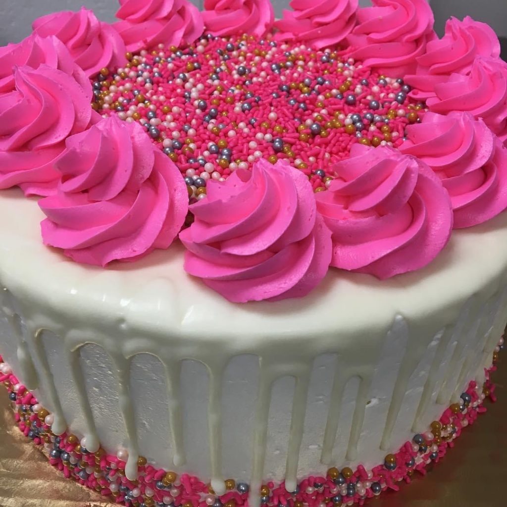 Drip cake with Pink Buttercream Swirls and Mixed Pearls and Sprinkle topping a