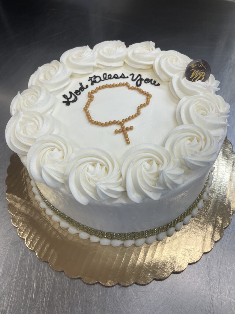 White cake that reads "God bless you"